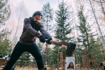 A man chops wood with an ax in the forest.