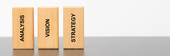 analysis, vision and strategy printed on wooden pillars