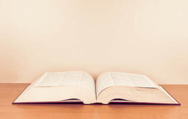 Open dictionary close up on a wooden table