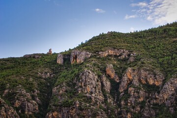 Fototapeta na wymiar Beautiful mountainous landscape with green trees and brown stone in Chulilla, Valencia, Spain