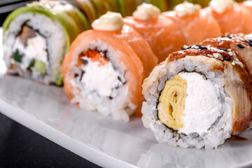 Fresh tasty sushi rolls laid out in the form of a dragon with ginger and wasabi