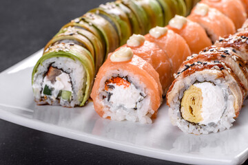 Fresh tasty sushi rolls laid out in the form of a dragon with ginger and wasabi