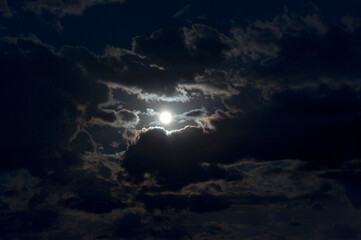 Fototapeta na wymiar A full moon’s glow in the sky at night. 
