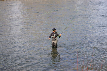 Fly fisherman hooking into a steelhead trout on the Salmon River in Idaho, USA