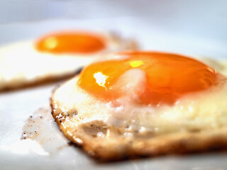 fried eggs close up on a white background