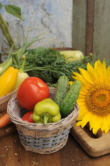 Summer vegetable frame made with sunflowers and assorted fresh vegetables on vintage wooden board