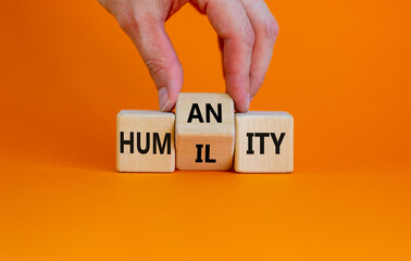 Humility vs humanity symbol. Businessman turns cubes and changes the word 'humility' to 'humanity'....
