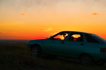 Plakat Meeting the sunset from a high slope in the cabin of the car.