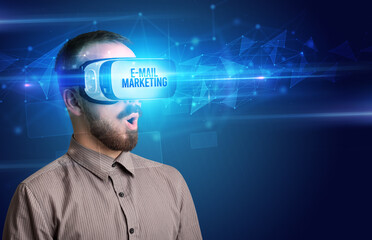 Businessman looking through Virtual Reality glasses with E-MAIL MARKETING inscription, cyber security concept