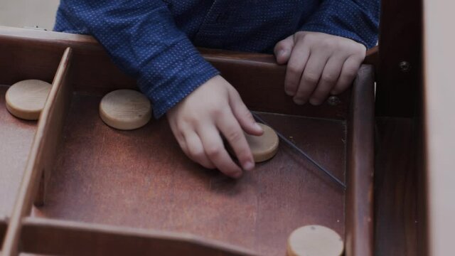 Boy hands are trying to play phuket, wooden round chip suddenly flies from above
