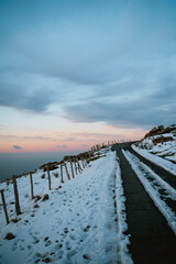 Snowy road on the hills of Jaizkibel with a beautiful gradient sunset sky in the background