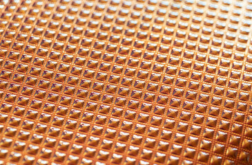 texturized golden surface close-up, selective focus. creative fashion background.