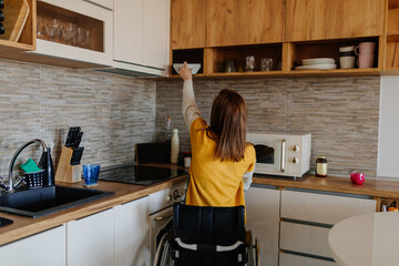 Woman in wheelchair reaching for bowls