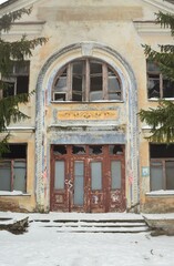 We see the front entrance to an old, majestic, abandoned building