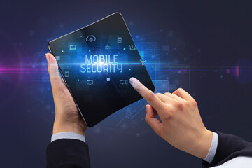 Businessman holding a foldable smartphone with MOBILE SECURITY inscription, cyber security concept