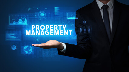 Hand of Businessman holding PROPERTY MANAGEMENT inscription, business success concept