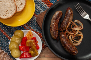 Traditional ukrainian transcarpathian  sausage gurka in a pan, bread and pickled vegetables
