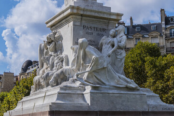 Fototapeta na wymiar Fragment of Louis Pasteur monument. Marble monumental statue Louis Pasteur located in the center of the Place de Breteuil. Paris, France.