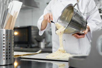 Pastry chef pours the biscuit on the baking parchment
