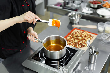Steel pot with boiling caramel for making pralines