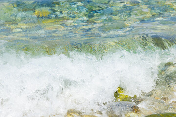 Sea wave and pebble. Summer vacation concept. Sea wave with foam incident on the coastal shingle. Travel concept