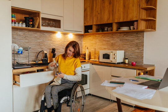 Woman in a wheelchair with her cat in the kitchen