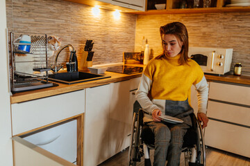 Fototapeta na wymiar Woman in wheelchair using dishwasher