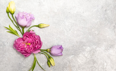 Floral frame on a gray background. Top view and copy space. Delicate lilac roses and eustoma. Corner composition.