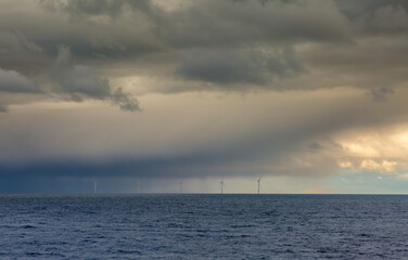 Several windmills off the coast of Tynemouth in the northeast of England, on a cloudy with a faint...