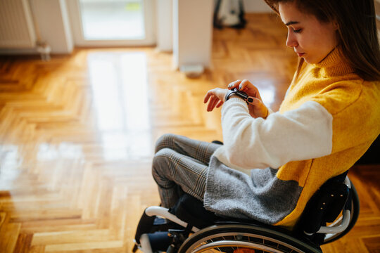 Female in wheelchair checking her smart watch - Powered by Adobe
