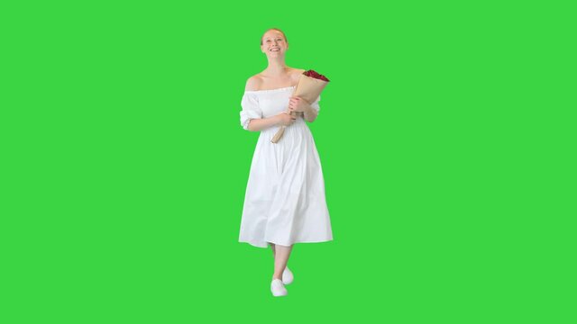 Dreamy young girl with beautiful bouquet walking on a Green Screen, Chroma Key.