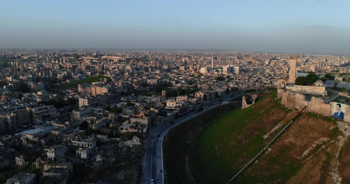 Drone flying over the citadel of Aleppo under the sunset. We can see the syrian city all over the horizon 4K