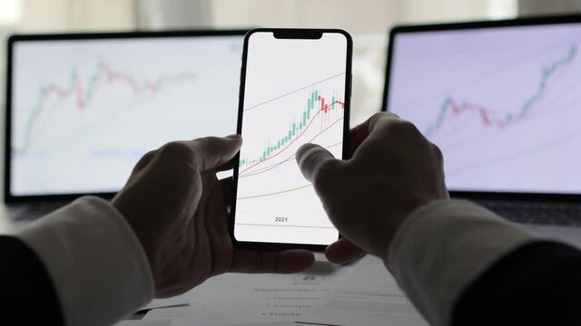 investment stockbroker stock market analysis price trend. Stock market trader analyzing bitcoin price trend. Investment broker trading bitcoin crypto currency using phone and laptop. Multiple devices