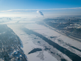 The frozen Dnieper river in Kiev in sunny weather. Aerial drone view. Winter sunny morning.