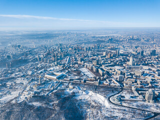 Obraz premium Snowy Kiev in sunny weather. Aerial drone view. Winter frosty morning.