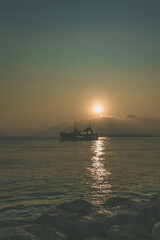 Fototapeta na wymiar boat on the sea at orange sunset time