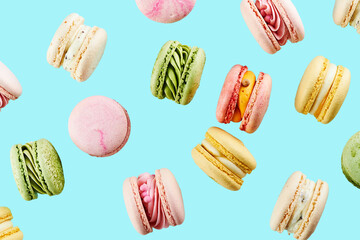 Traditional french cookies macarons of different colors and taste isolated on turquoise blue background  and flying in the air. Sweet cookies macaron.