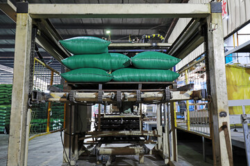 Workers are busy in the feed packaging production line.