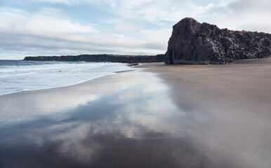 Reflection of the sky in the sand of the beach wet by the waves