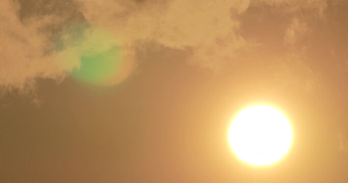 Clouds float against the sun at sunset, cloudscape, orange color, close up