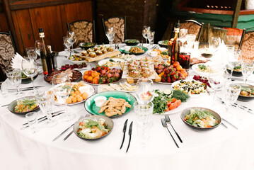 The feast of the round table full of delicious food and snacks, a beautiful setting, catering, holiday in the fresh air