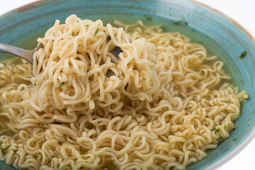 Bowl of instant noodle soup with silver spoon