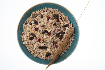 Breakfast oatmeal with nuts and dried fruits in blue bowl on white