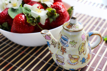 ripe ripe strawberries on a white plate and jasmine flowers 
