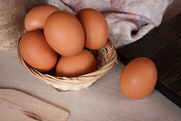 Fresh chicken eggs on a textured wooden table. 