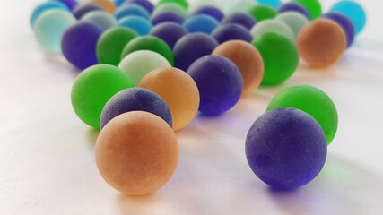game clickers or colored glass balls scattered on a white background. back lighting