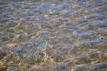 Smooth rocks in clear water on beach