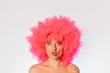 Woman wearing pink wig standing with open mouth