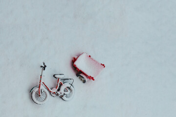 Abandoned Children's Bike with Tin Toy Trailer under Snow in the backyard. A Mess in the Yard. Post Apocalyptic.