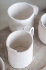 White handmade clay cups. Tea set on the table. White kitchen items